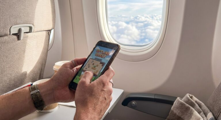 Passenger playing offline mobile game on smartphone during long-haul flight with airplane window visible